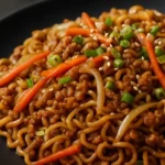 Die Besten gebratenen Ramen nach unserem Instant Ramen Rezept zubereitet, serviert auf einem dunklen Teller.