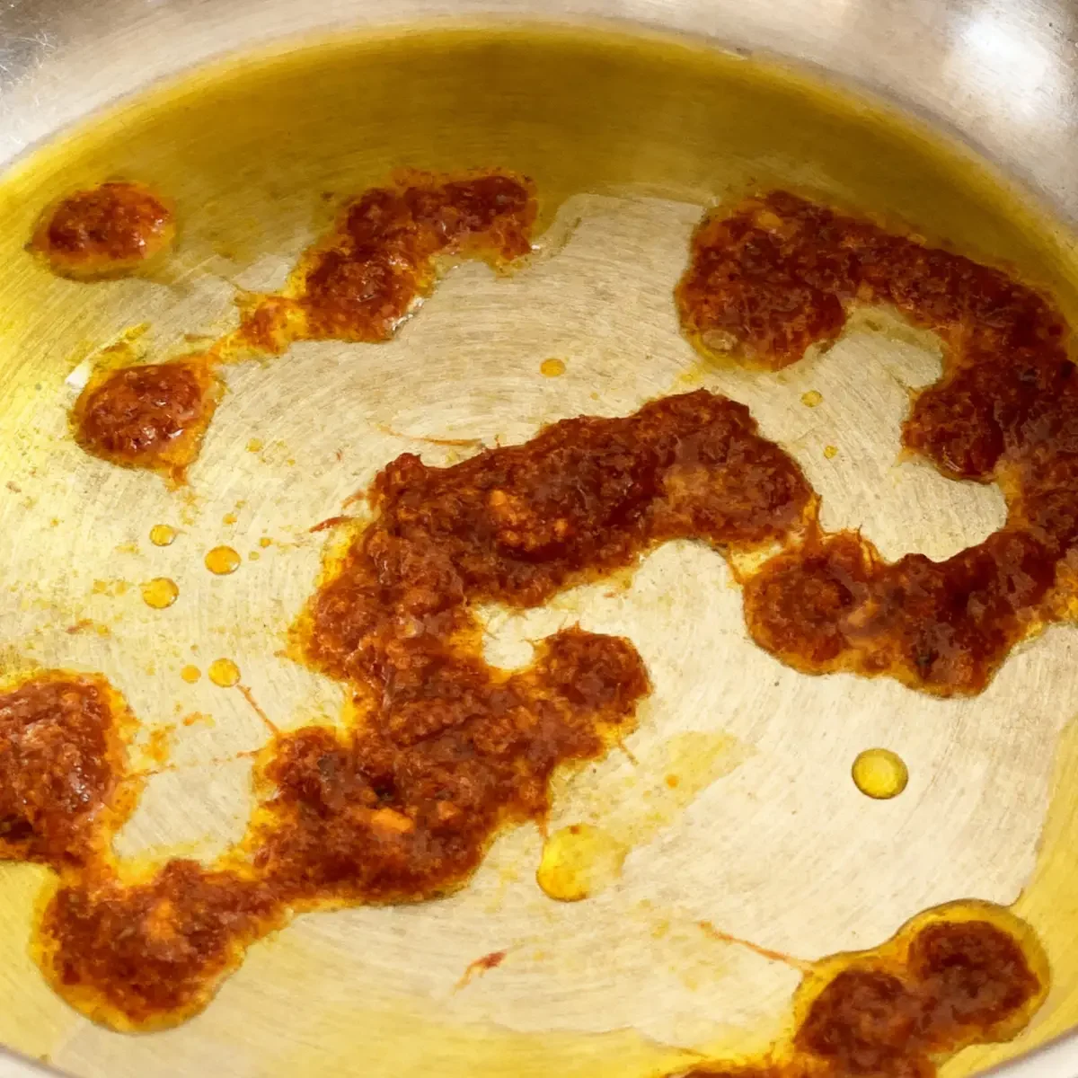 Currypaste wird in einem Topf angebraten