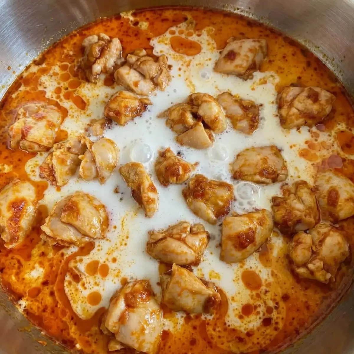 Kokosmilch und Hähnchen köchelt in einem Topf