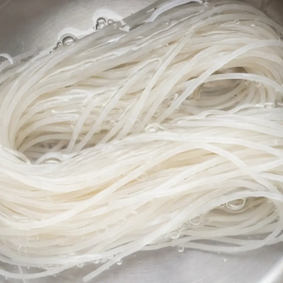 Reisnudeln in einer Schüssel einweichen