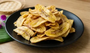 Thailändische frittierte Bananenchips auf schwarzem Teller, knusprig und goldgelb serviert