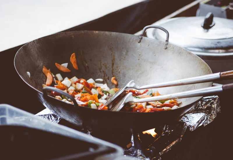 Wok gefüllt mit Gemüse auf einem Herd